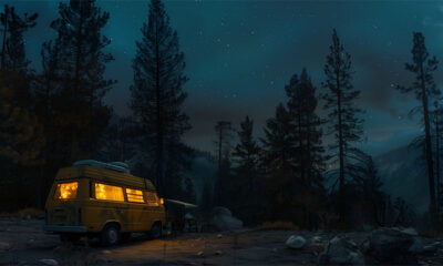 A yellow camper van with lights on is parked in a forest clearing at night, surrounded by tall pine trees under a starry sky. Camping-themed print available in A1 to A4 sizes.