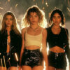 Three young women in fashionable outfits stand side by side, with sparks flying in the background and a smoky atmosphere. Cinematic-style teen attitude poster available in A1 to A4 sizes.