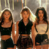 Three young women in fashionable outfits stand side by side with confident expressions, while fireworks light up the background. Cinematic-style teen attitude poster available in A1 to A4 sizes.