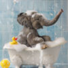 A baby elephant sits in a white bathtub filled with bubbles next to a yellow rubber duck, with water splashing against a blue tiled wall. Cute animal poster available in A1 to A4 sizes.