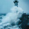 Large waves crash against a stone pier and lighthouse during a storm, sending spray into the air under overcast skies. Nature and landscape print available in A1 to A4 sizes.
