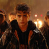 Three teenage boys stand in the rain at night, looking serious, with bright lights and sparks in the blurred background. Cinematic-style teen attitude poster available in A1 to A4 sizes.