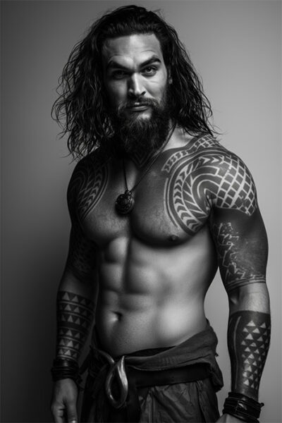 An art portrait of Jason Momoa, with long hair, a beard, and tribal tattoos on his arms and chest stands shirtless, wearing a necklace and wristbands, against a plain background. Wall art print available in A1 to A4 sizes.
