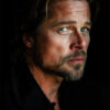 A portrait of Brad Pitt with light eyes, light brown hair, and a short beard, looking sideways into the camera against a dark background. Wall art print available in A1 to A4 sizes.
