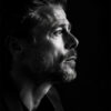 Black and white side profile portrait of Brad Pitt, the acclaimed actor, with short hair and a beard, looking thoughtfully into the distance against a dark background. Wall art print available in A1 to A4 sizes.