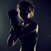A woman wearing boxing gloves stands in a defensive pose, lit from behind, casting her face and body into shadow. Poster print available in A1 to A4 sizes.