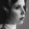 Black and white portrait of a woman with detailed braided hair styled in two side buns, wearing a high-collared white outfit, gazing thoughtfully to the side, evoking the iconic look of Princess Leia from Star Wars. Fantasy art poster available in A1 to A4 sizes.