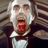 A man dressed as Dracula with pale skin, fangs, blood around his mouth, and a black cape strikes a dramatic pose—channeling vintage vampire style. Horror poster available in A1 to A4 sizes.