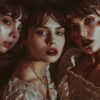 Three women in vintage lace dresses with dramatic makeup; two have blood and wounds on their necks, evoking a vampire or horror theme. Fantasy art poster available in A1 to A4 sizes.