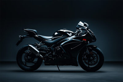 Side view of a sleek black Suzuki GSXR-1000 in a dimly lit studio setting, highlighting its aerodynamic design and modern features. Wall art print available in A1 to A4 sizes.