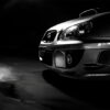 Close-up view of the front right side of a silver Subaru Impreza with prominent headlights, in a dimly lit setting. Wall art print available in A1 to A4 sizes.