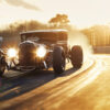 A vintage hot rod car drives on a racetrack at sunset with its headlights on and blurred background showing speed. Wall art print available in A1 to A4 sizes.