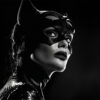 A woman in a black cat costume with a mask and cat ears looks over her shoulder in dramatic lighting. Fantasy art poster available in A1 to A4 sizes.