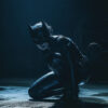 Woman in a black cat costume crouches on the floor in a dimly lit setting with a spotlight highlighting their figure. Fantasy art poster available in A1 to A4 sizes.