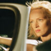 Uma Thurman sits in the driver’s seat of a car, looking intently ahead with her hand on the steering wheel, in a scene from the movie Kill Bill. Wall art print available in A1 to A4 sizes.