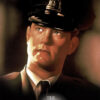 A man in a police officer uniform looks upward in dim lighting. The text The Green Mile (1999) appears at the bottom of the image. Movie poster print available in A1 to A4 sizes.