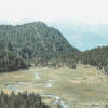 A winding Plateau River flows through a grassy valley surrounded by densely forested hills and distant mountains under a pale sky. Nature and landscape poster print available in A1 to A4 sizes.