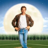 A man in a brown leather jacket and jeans stands on a baseball field in front of a glowing full moon, with the text Field Of Dreams above him, evoking the magic of the iconic 1989 movie. Movie poster print available in A1 to A4 sizes.