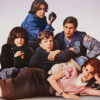 Five teenagers sit closely together against a plain background, with The Breakfast Club—John Hughes’ iconic 1985 movie—written at the bottom in bold red text. Movie poster print available in A1 to A4 sizes.