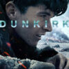 A young man with a dirt-streaked face lies on a sandy beach amid debris, with smoke and explosions in the background; the word DUNKIRK is overlaid, evoking a gripping scene from the 2017 Dunkirk movie. Movie poster print available in A1 to A4 sizes.