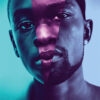 A split-image poster for the 2016 movie Moonlight, showing two faces of a Black male at different ages, with blue and purple lighting, and the title MOONLIGHT at the bottom. Movie poster print available in A1 to A4 sizes.