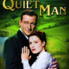 Movie poster for The Quiet Man (1952) showing a man and woman embracing in front of a green countryside landscape, with the title in large yellow letters above them. Movie poster print available in A1 to A4 sizes.