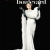 A woman in an elegant white gown and gloves poses dramatically beneath the bold text Sunset Boulevard on a black background, evoking the glamour of the iconic 1950 movie. Movie poster print available in A1 to A4 sizes.
