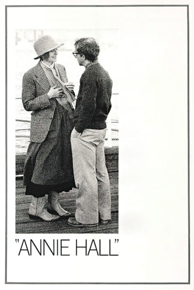 Two people stand facing each other, talking on a wooden walkway; one wears a hat and long skirt, the other glasses and casual clothes—a scene from Annie Hall (1977). The text below reads ANNIE HALL. Movie poster print available in A1 to A4 sizes.