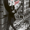 A man in a suit and hat hangs from the hands of a large clock on a building above a city street, recreating Harold Lloyd’s iconic scene from the silent comedy classic, Safety Last!. Movie poster print available in A1 to A4 sizes.