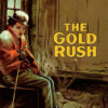 A person dressed warmly sits by a stove in a rustic room, with The Gold Rush (1925) by Charlie Chaplin displayed prominently on the wall. Movie poster print available in A1 to A4 sizes.