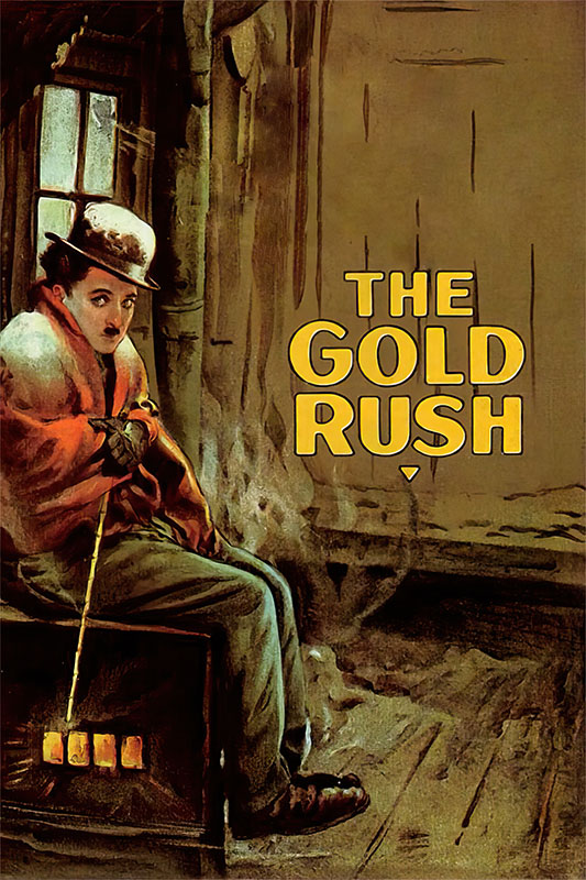 A person dressed warmly sits by a stove in a rustic room, with The Gold Rush (1925) by Charlie Chaplin displayed prominently on the wall. Movie poster print available in A1 to A4 sizes.