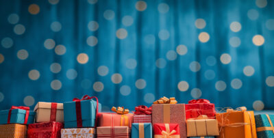 A row of assorted wrapped gift boxes with ribbons sits at the bottom of this customizable poster, set against a blue background with circular light bokeh effects. Add your own text for a personalized touch. Prints available in A1 to A4 sizes.