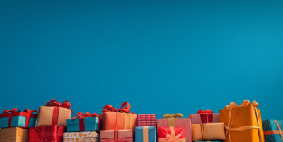 A row of assorted gift boxes and bags, wrapped in colourful paper and ribbons, arranged at the bottom of a blue background—perfect for a customizable poster where you can add your own text. Prints available in A1 to A4 sizes.