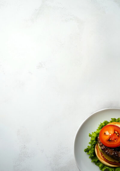 A plate with a hamburger topped with lettuce and tomato is partially visible in the bottom right corner, creating a perfect Burger Menu Background against a light textured surface. Add Your Own Text to customize your menu design. Menu background available in A1 to A4 sizes.